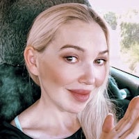 a blonde woman sitting in the back seat of a car